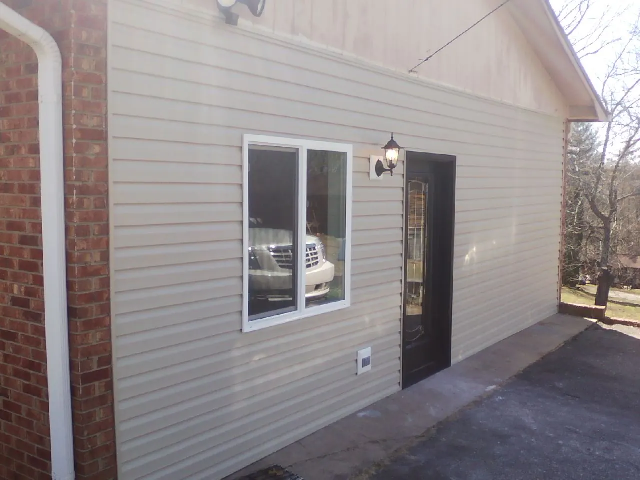 New vinyl siding and entry door on a room addition in Fayetteville